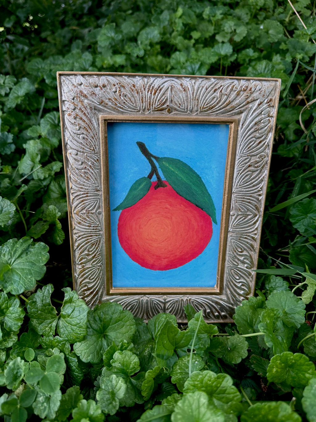 Framed orange oil pastel print displayed on wall – gallery art