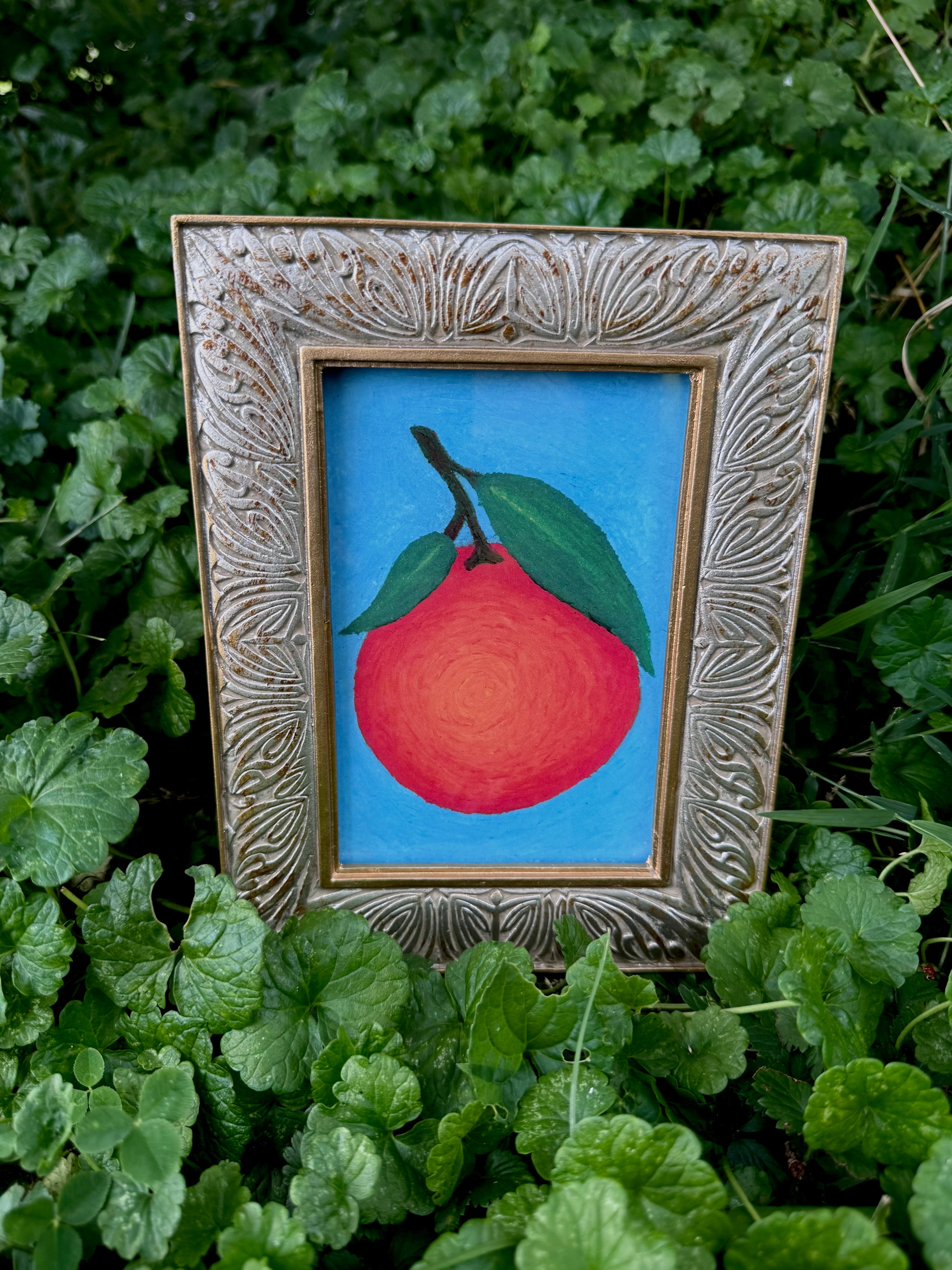 Framed orange oil pastel print displayed on wall – gallery art