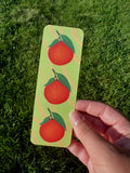 Clementine bookmark with three orange clementines and green leaves on yellow-green stripe background