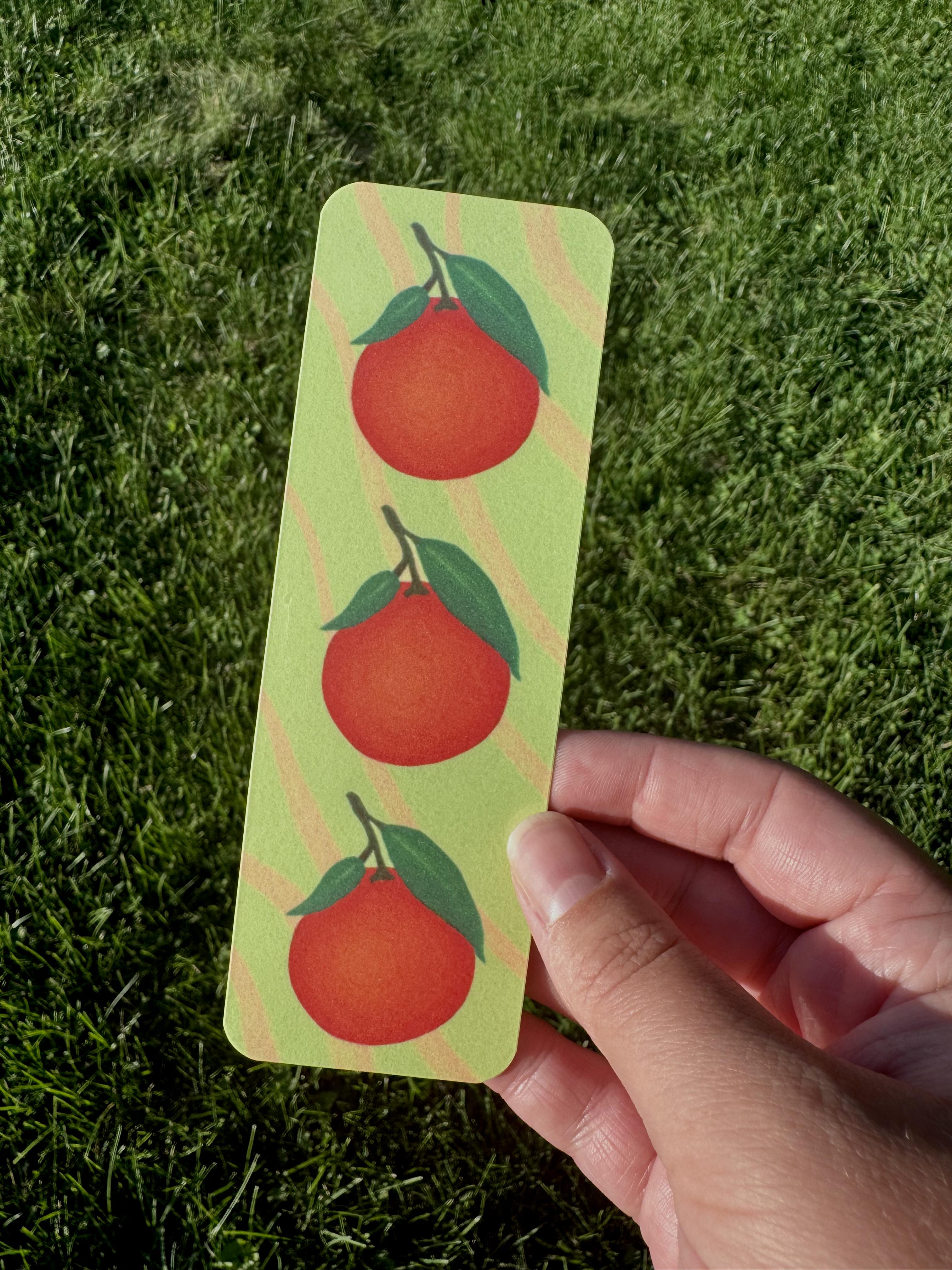 Clementine bookmark with three orange clementines and green leaves on yellow-green stripe background